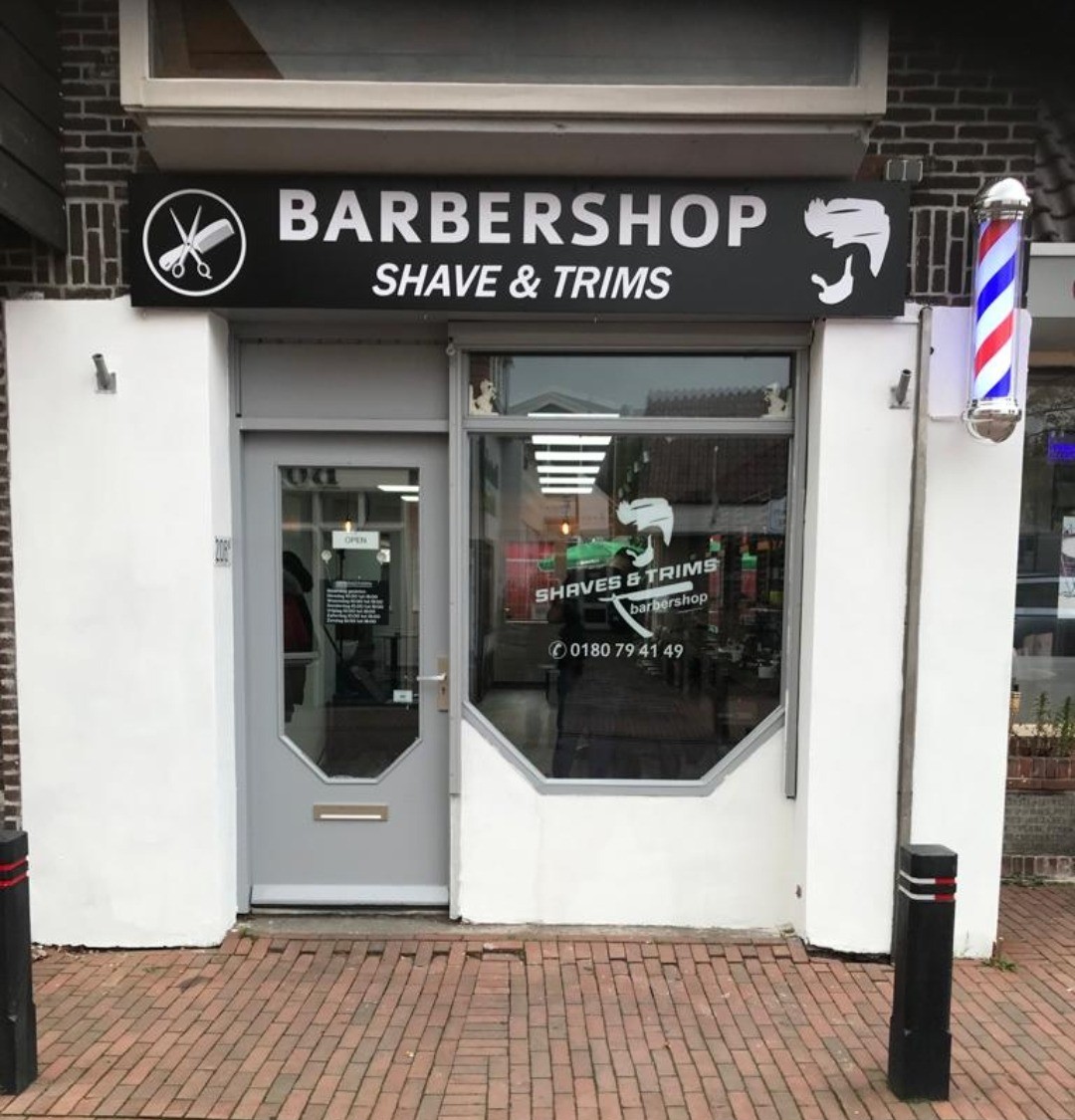 De winkelpui van Barbershop Shaves & Trims aan de Dorpsstraat 208 in Zevenhuizen, met het zwarte bord en de kapperspaal